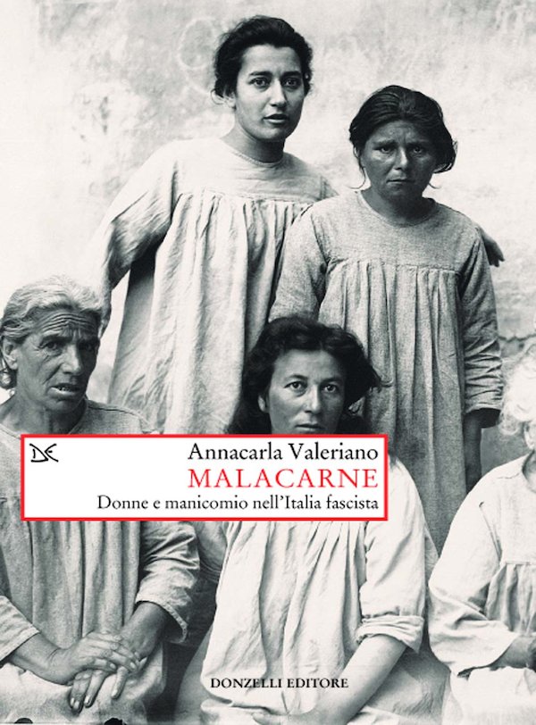 Copertina di Malacarne. Donne e manicomio nell'Italia fascista di Annacarla Valeriano: raffigura un gruppo di donne (due in piedi e due sedute davanti a loro) in una vecchia fotografia d'epoca in bianco nero. Si tratta di pazienti di un manicomio.